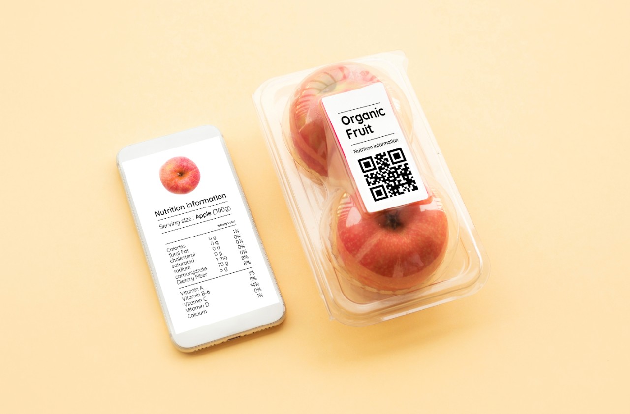 Nutrition information of organic fruit with apple in packaging and data from qr code on smart phone.food and healthy concepts ideas,top view